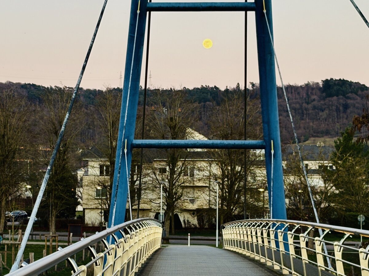 Moon framed by blue bridges in Walferdange